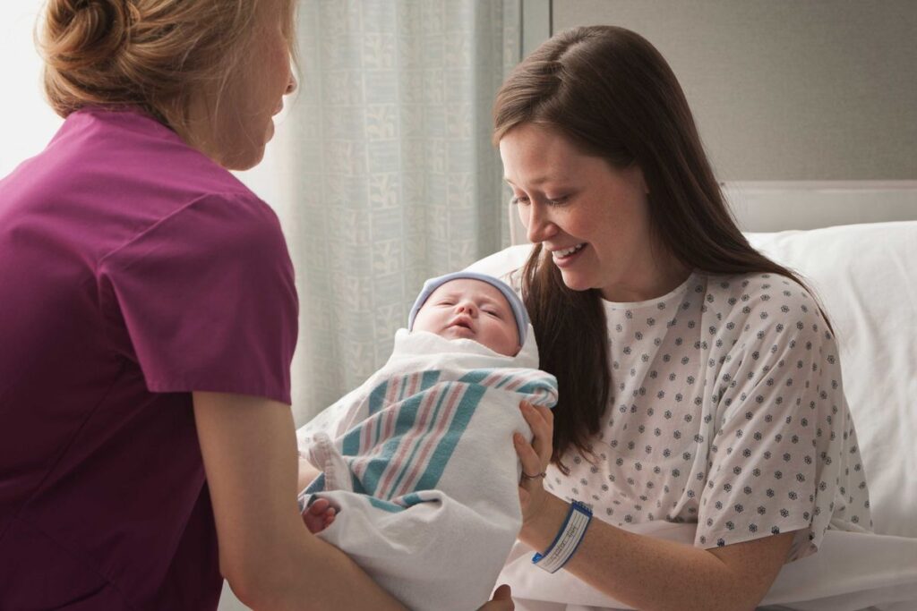 Labor and delivery nurse taking care of mother and baby